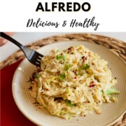 A fork twirling into a plate of creamy vegan cabbage alfredo topped with cilantro and red pepper flakes, with text reading 'How to Make Vegan Cabbage Alfredo — Delicious & Healthy.