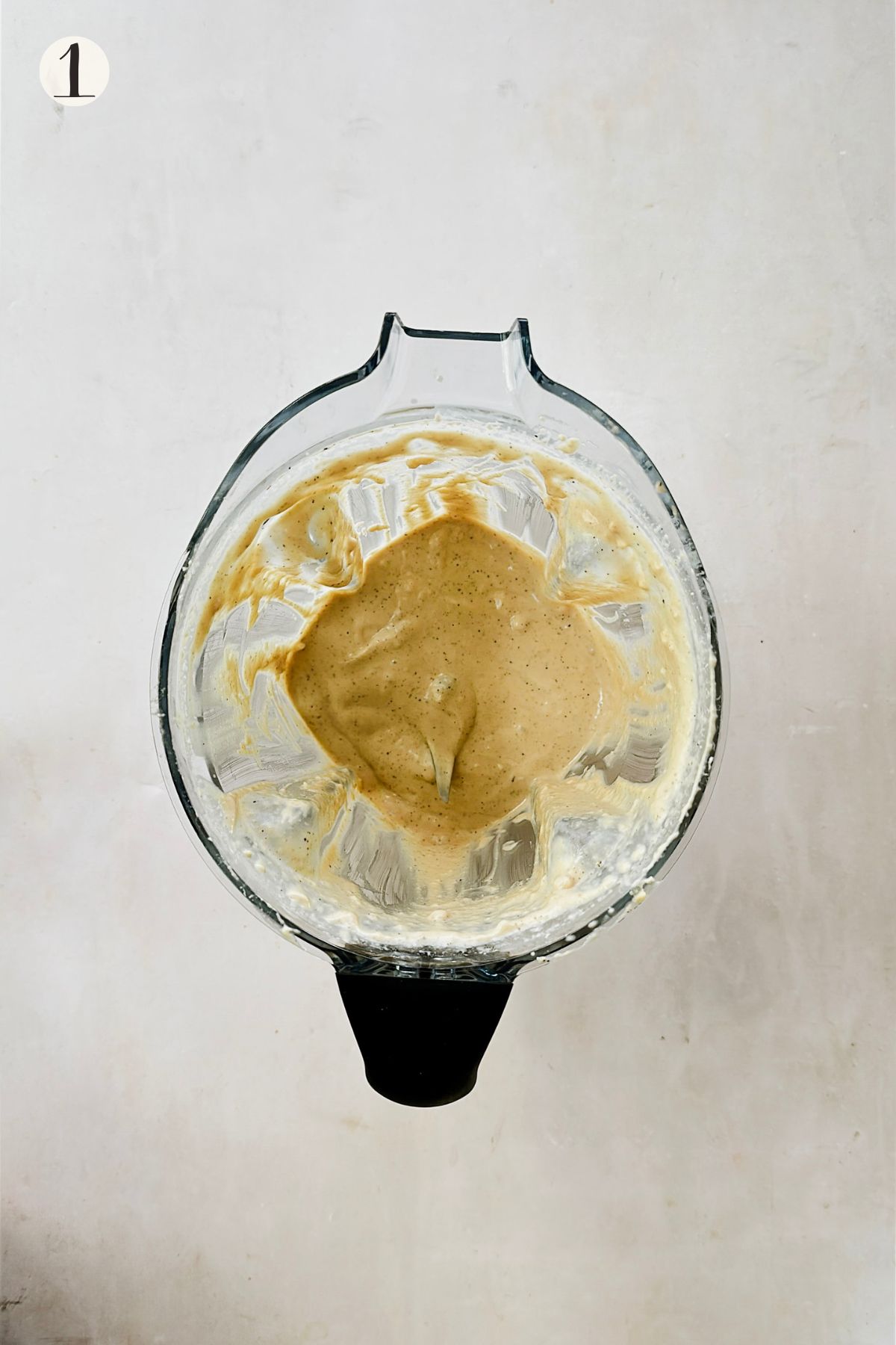 Creamy blended cashew alfredo sauce in a glass blender.