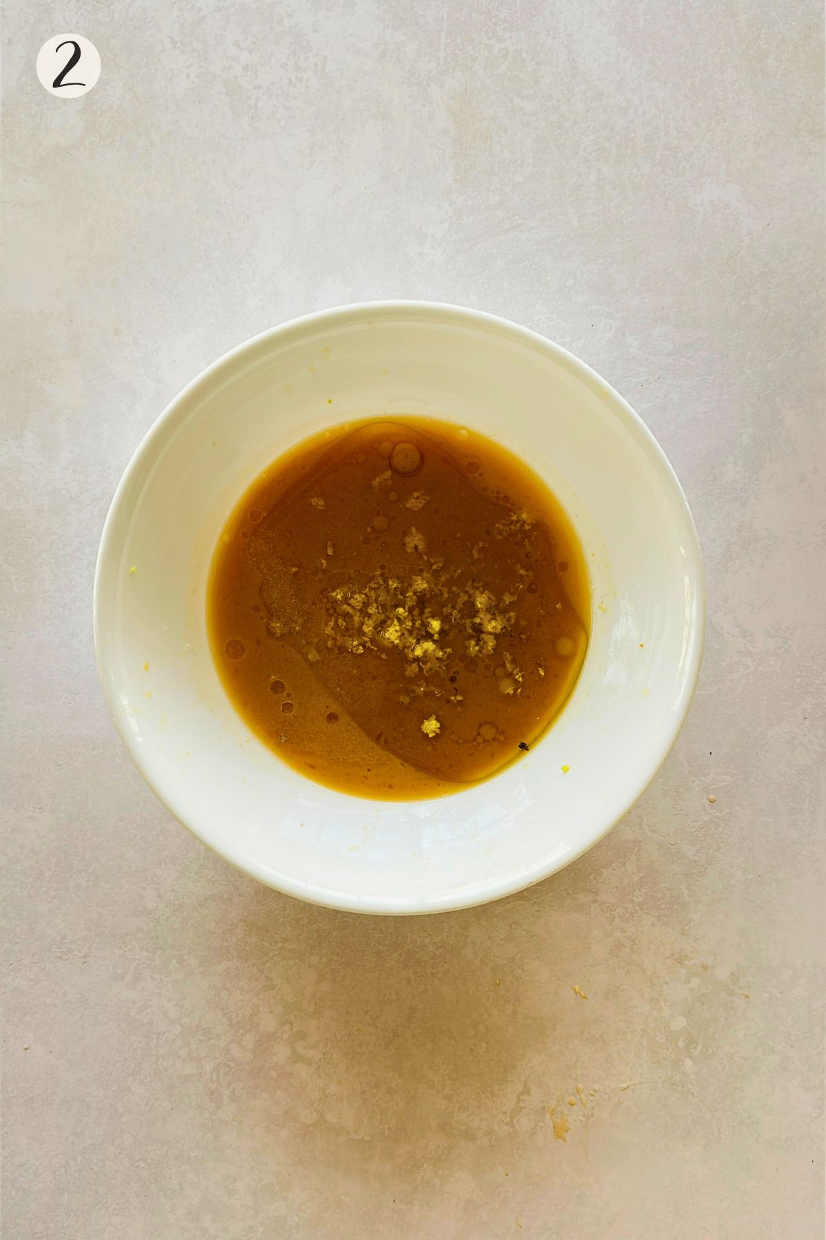 Golden miso citrus dressing in a white bowl with fall the ingredients in the bowl.