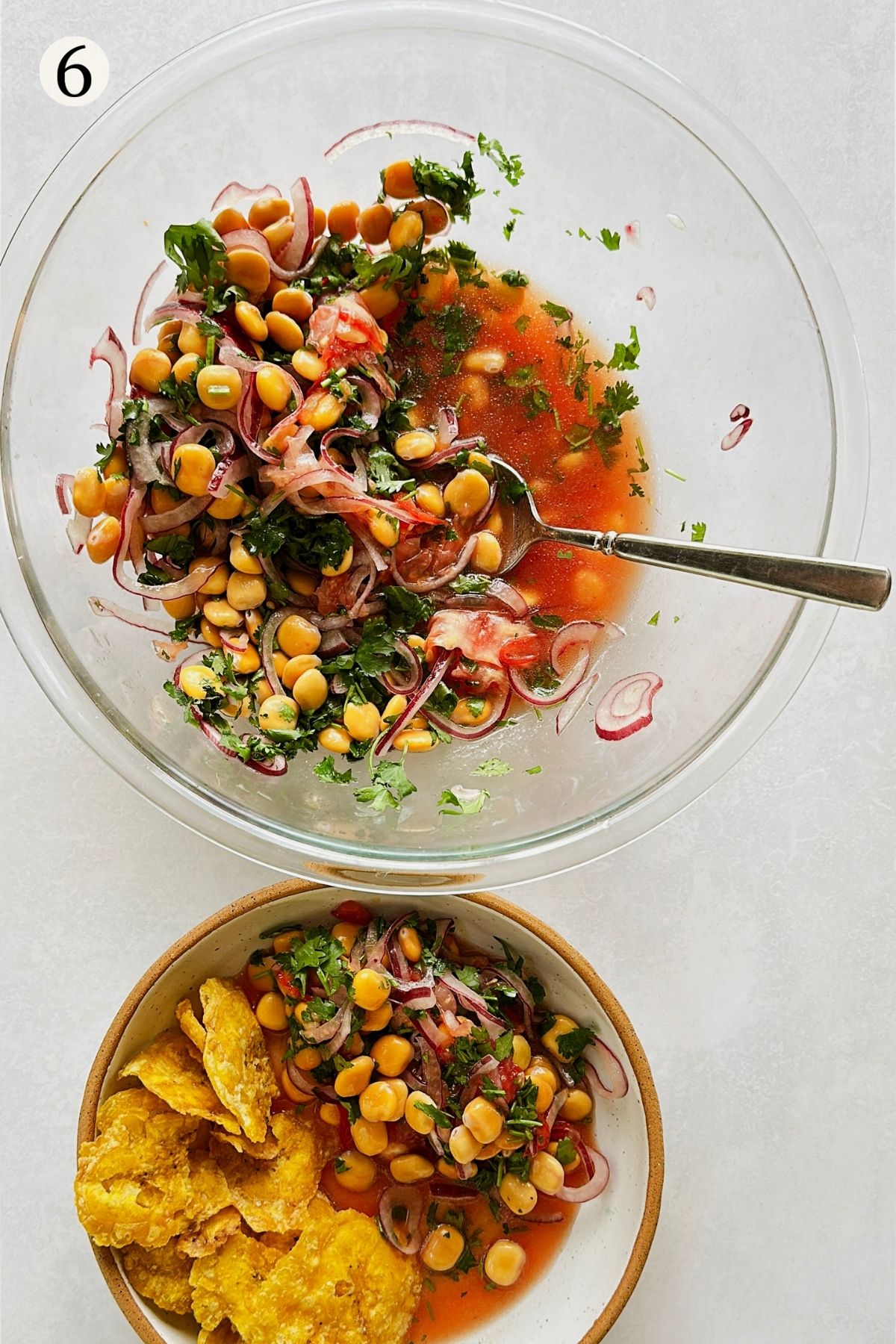 Step 6 of making ceviche de chochos: the finished vegan ceviche served in a bowl with plantain chips alongside, the mixing bowl and spoon behind it.