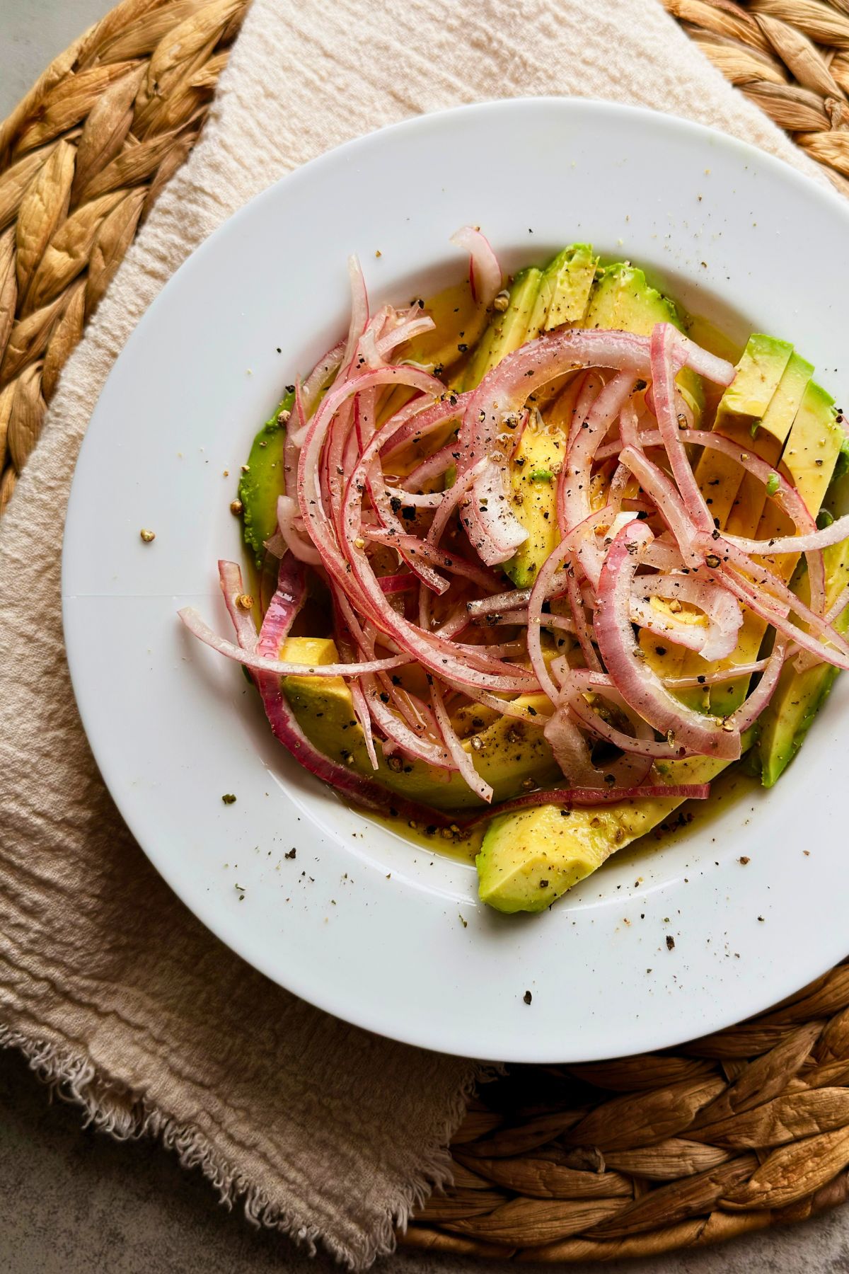 Cuban avocado salad with red onion and black pepper on a white plate.