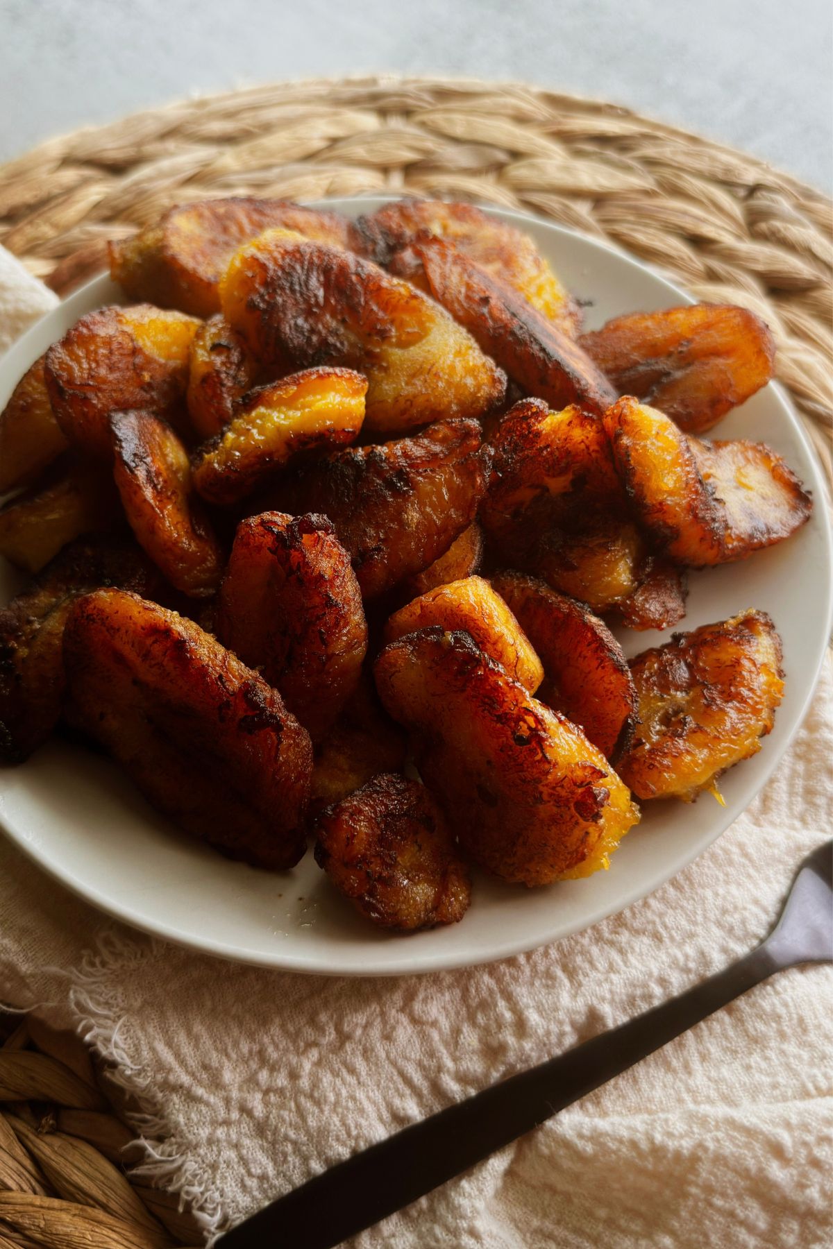 Cuban fried sweet plantains with caramelized edges on a white plate