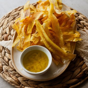 Crispy mariquitas served with garlicky mojo on a woven placemat.