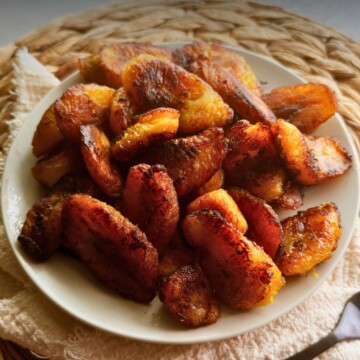 Caramelized plátanos maduros on a white plate.