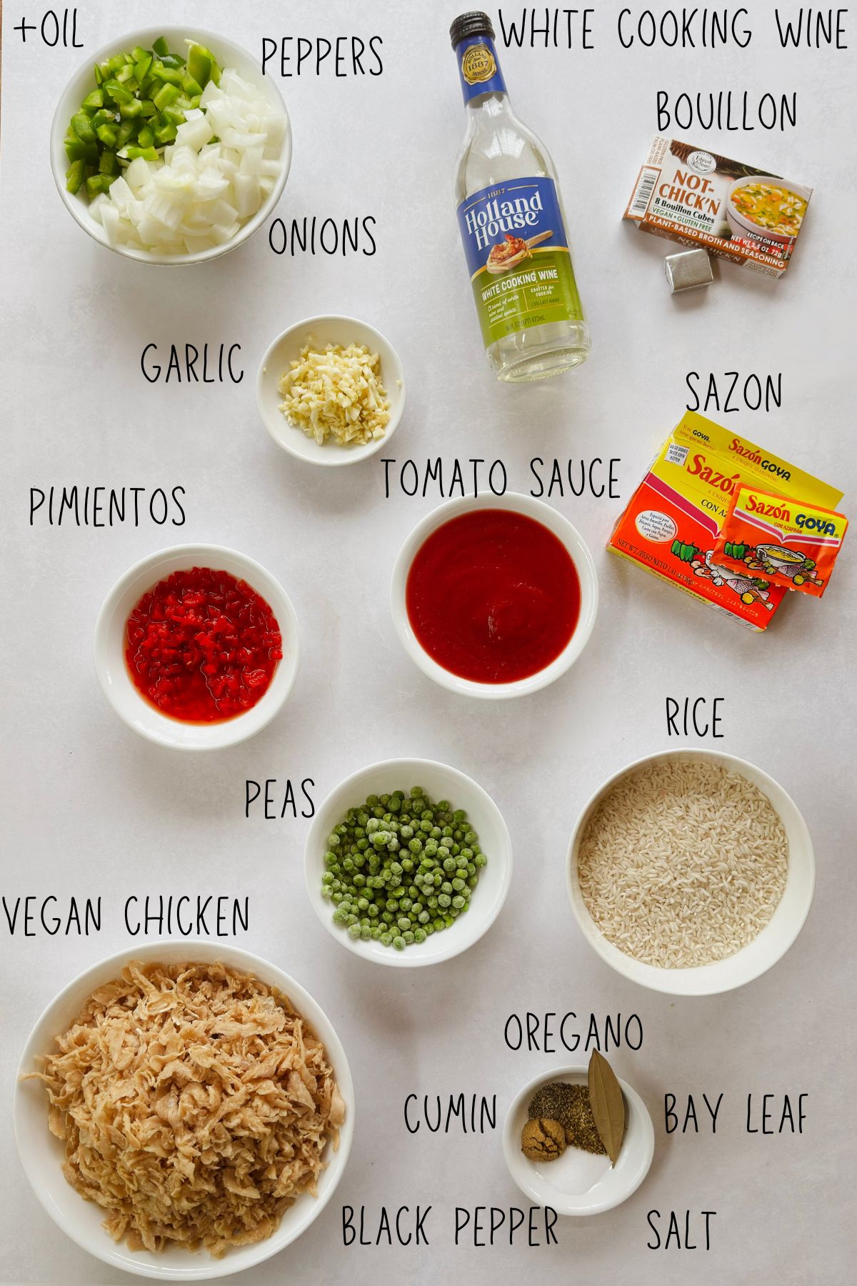 Labeled ingredients for vegan arroz con pollo: shredded vegan chicken, long-grain white rice, chopped onion and green pepper, garlic, tomato sauce, pimientos, peas, sazón, vegan bouillon, and white cooking wine.